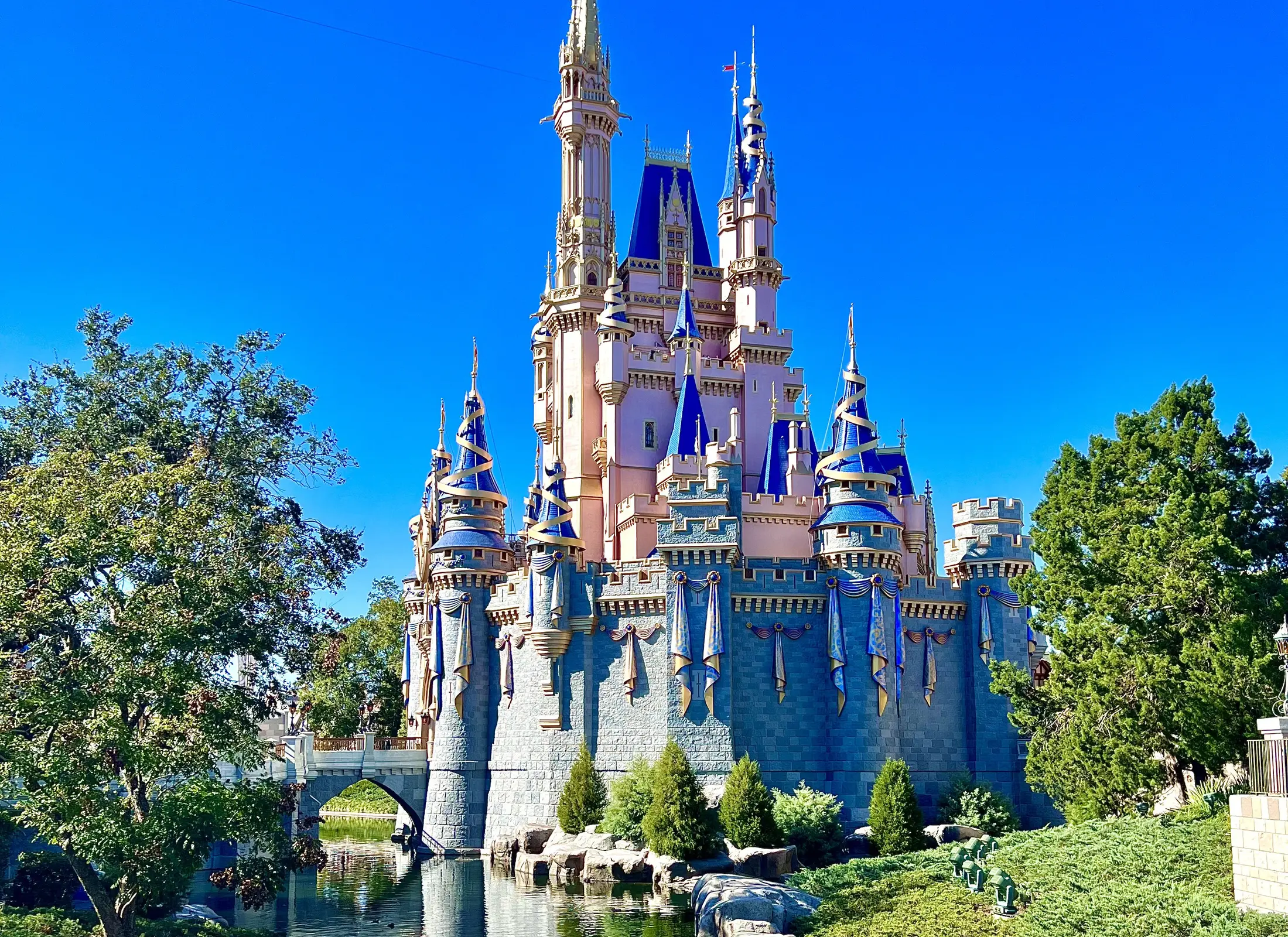 Cinderella Castle in its current blue and rose design beneath a bright sky