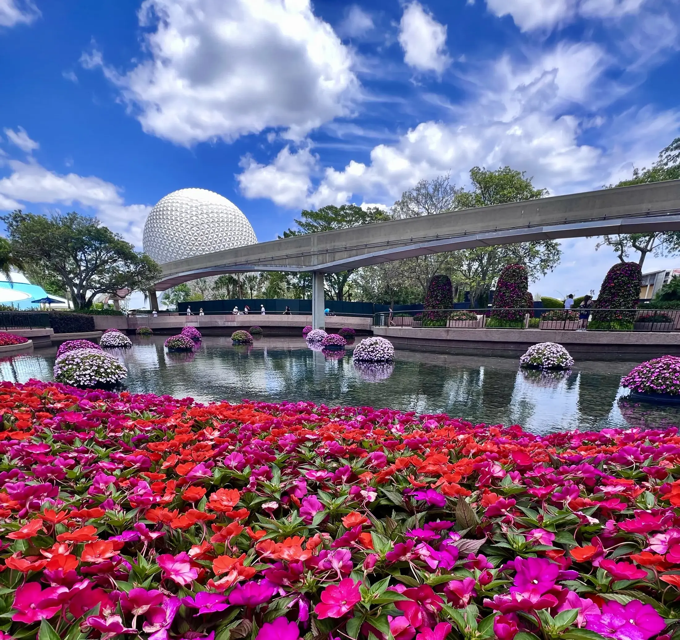 Spaceship Earth beyond colorful flowers during an EPCOT festival