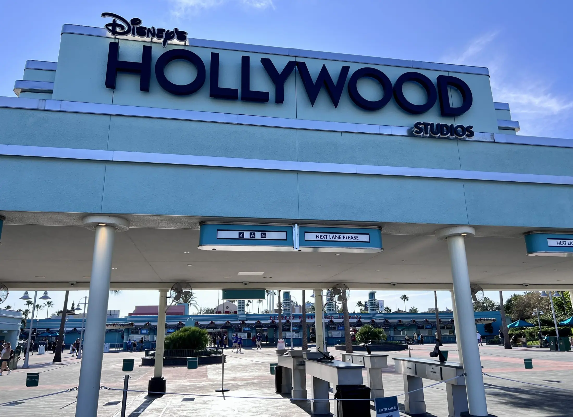 The iconic Disney's Hollywood Studios entrance marquee beneath a blue sky