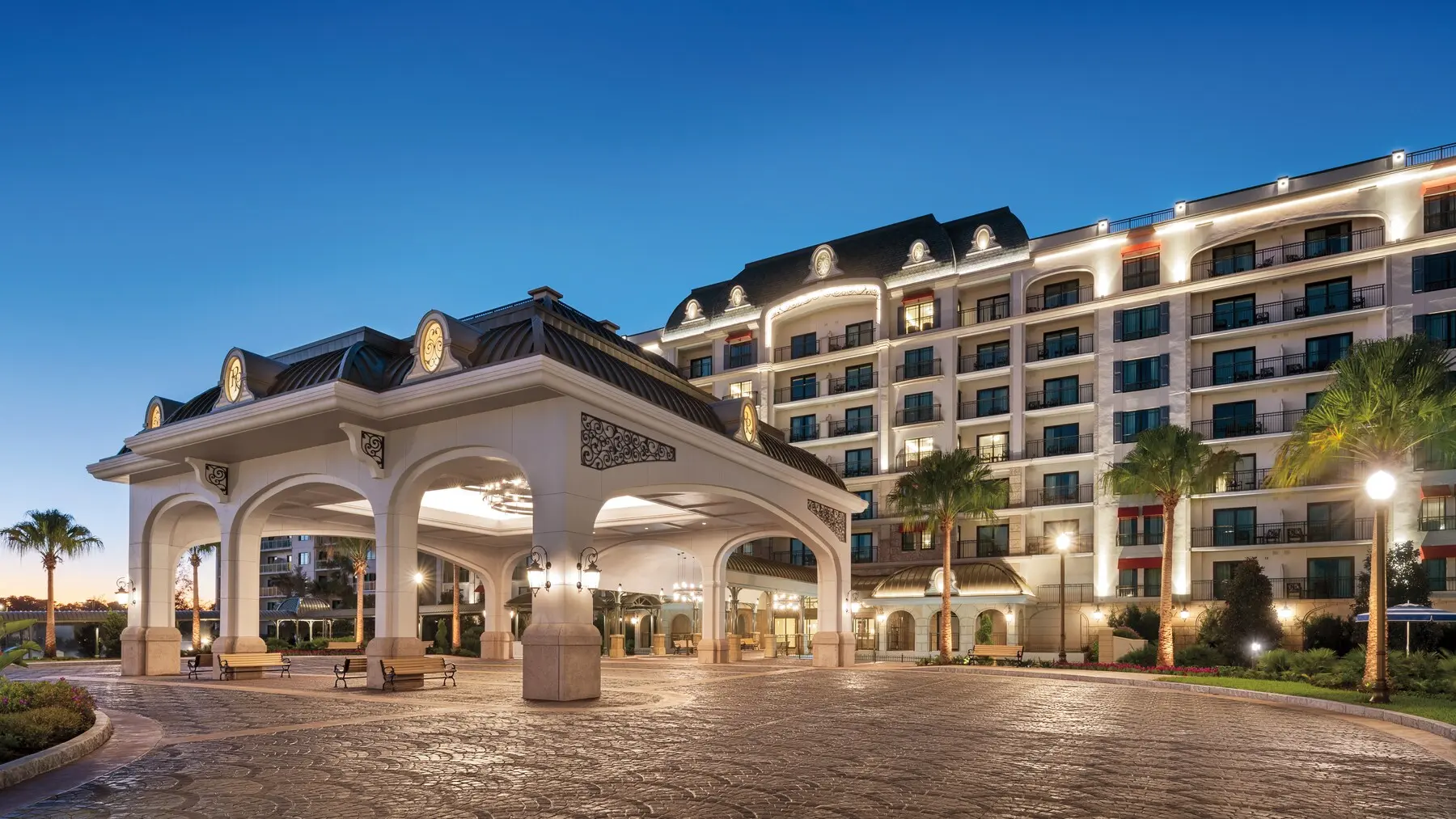 The illuminated entrance and villa tower at Disney’s Riviera Resort