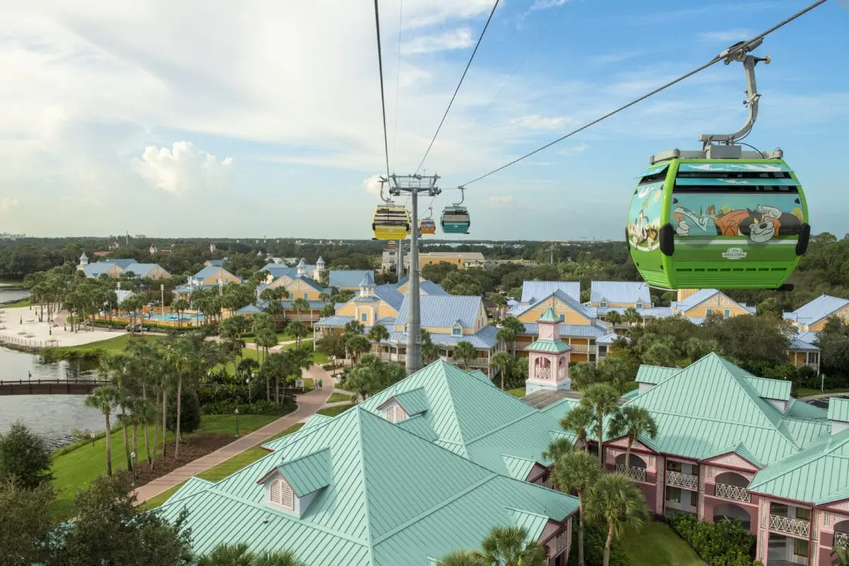 Disney Skyliner gondolas passing over the colorful villages of Disney's Caribbean Beach Resort