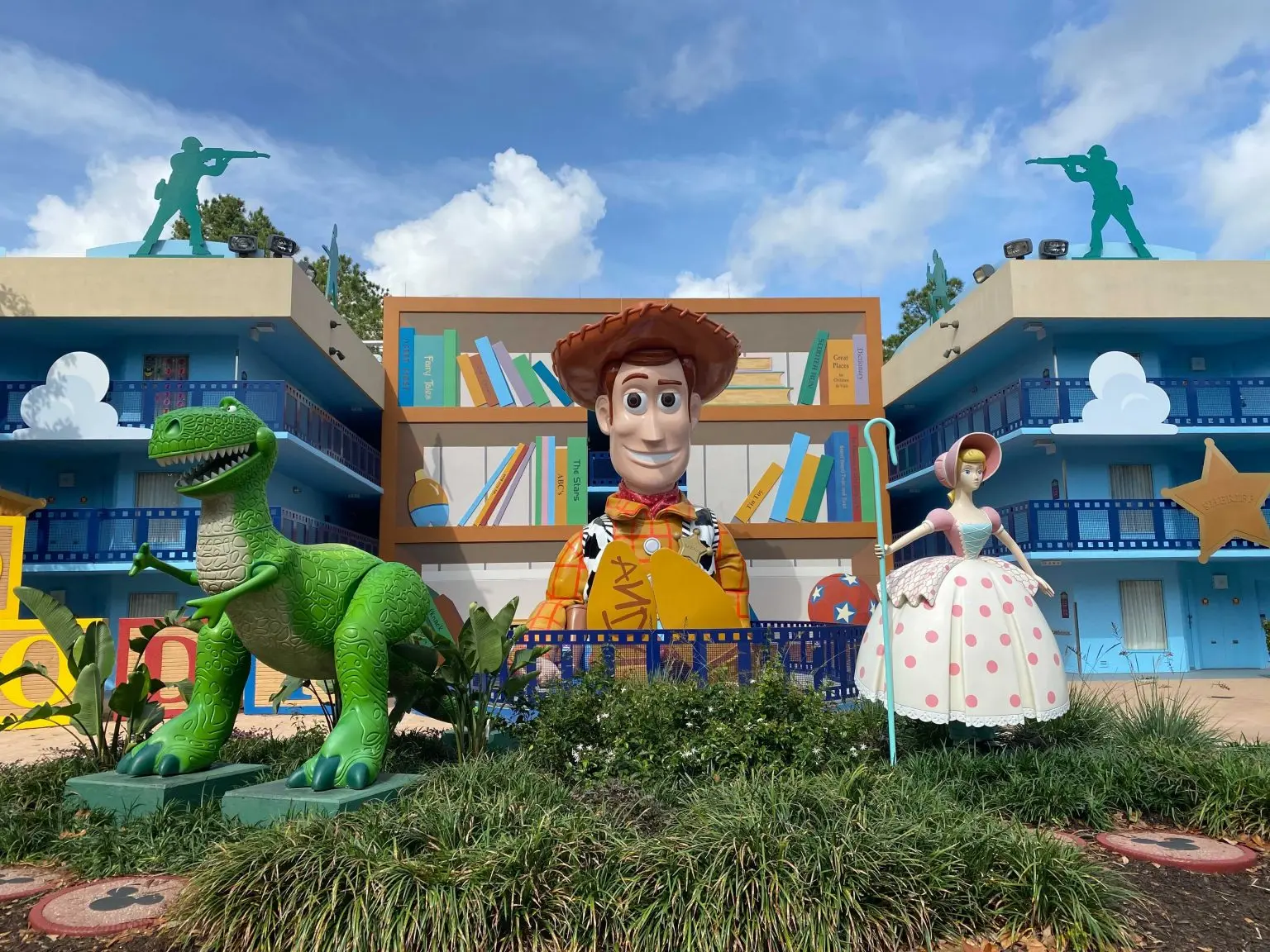 Woody, Rex and Bo Peep surrounded by Toy Story themed buildings at Disney's All-Star Movies Resort